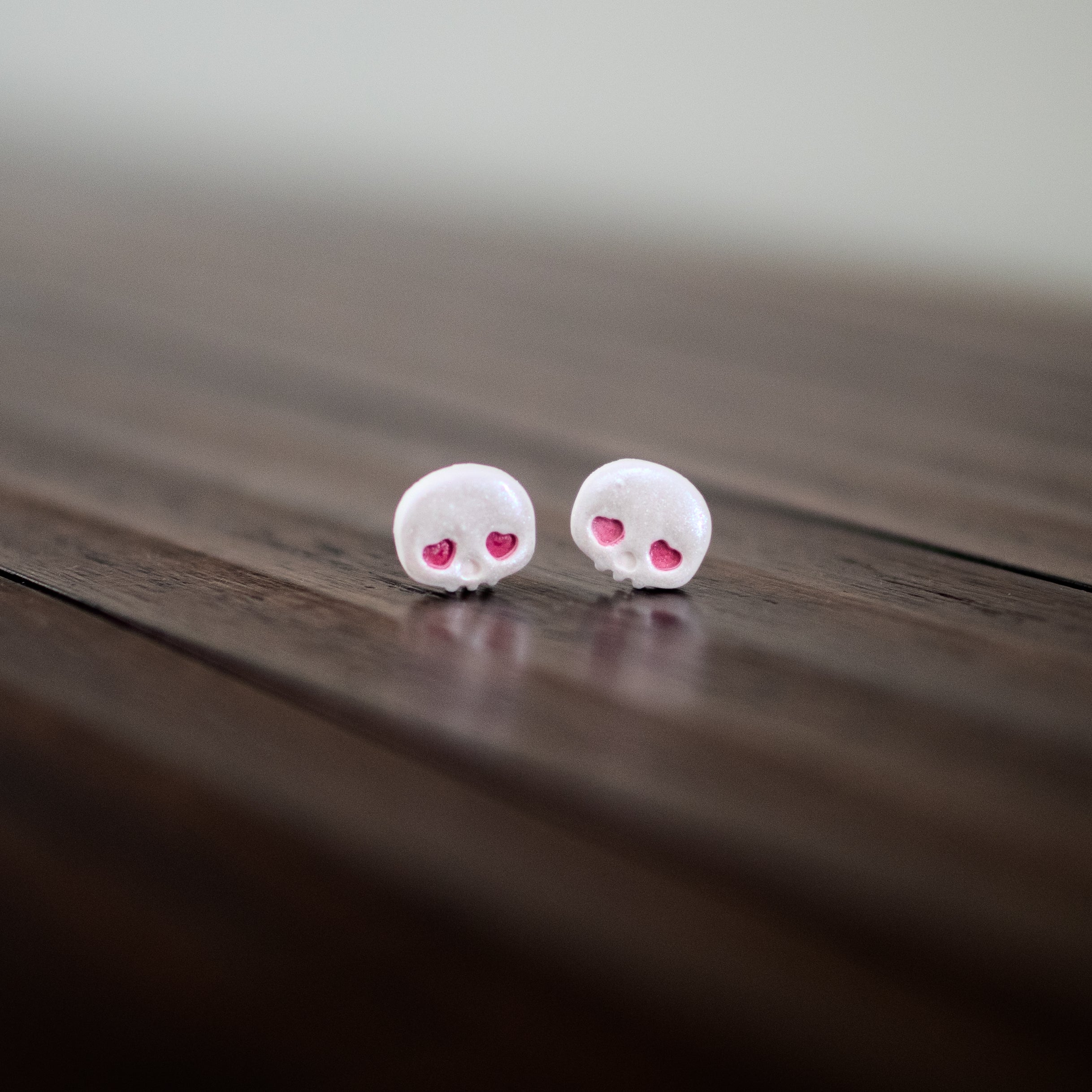 White skull earrings with red heart eyes 