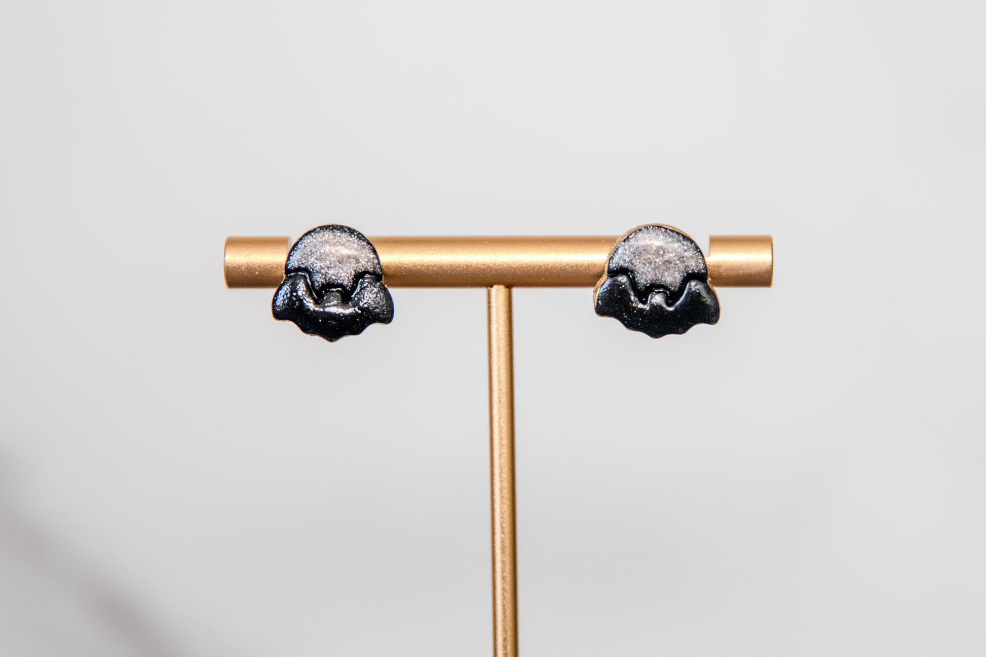 Stud earrings of black bat over shimmering moon