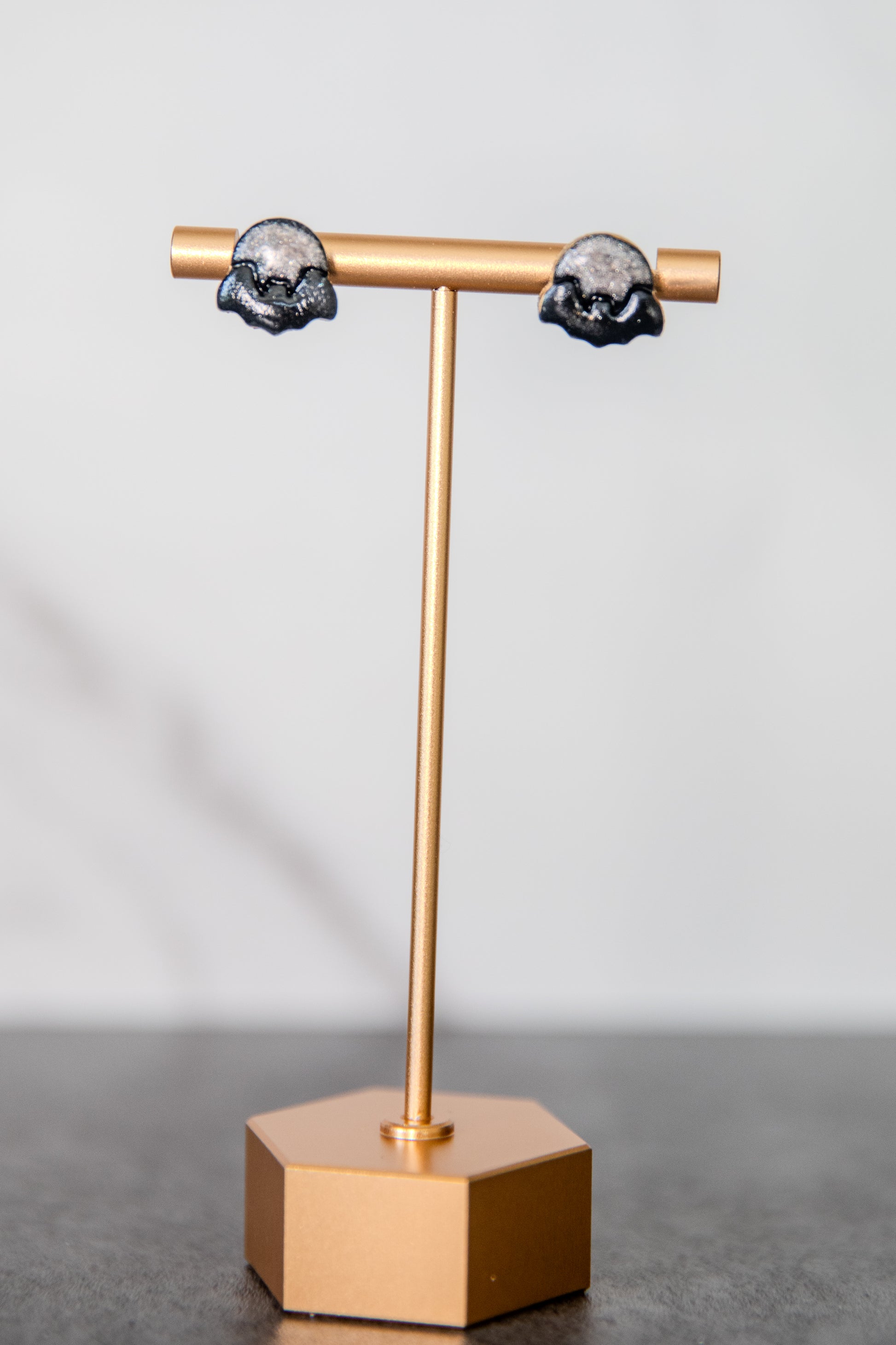 Stud earrings of black bat over shimmering moon