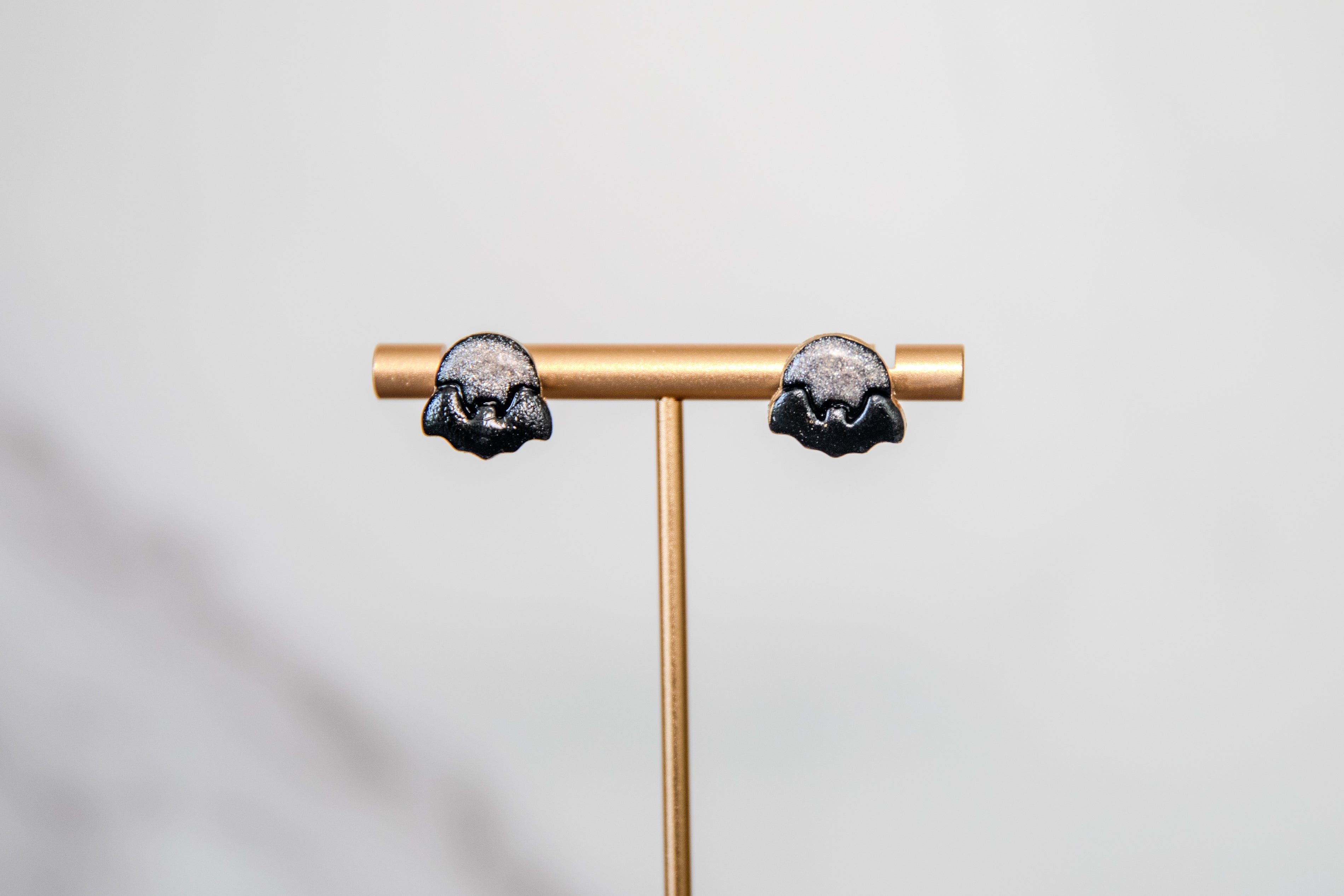 Stud earrings of black bat over shimmering moon