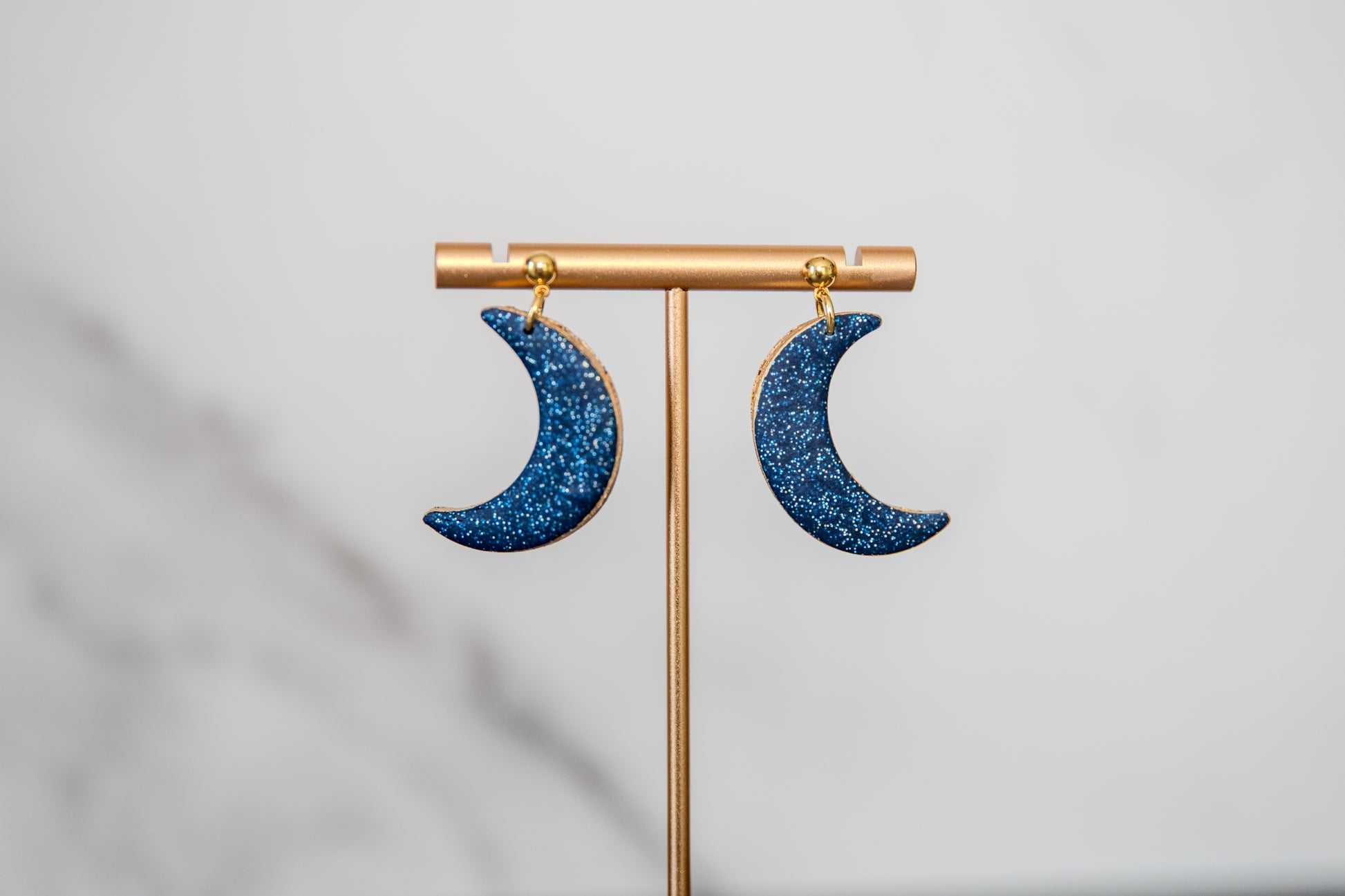 Blue glitter crescent moon earrings with gold edges