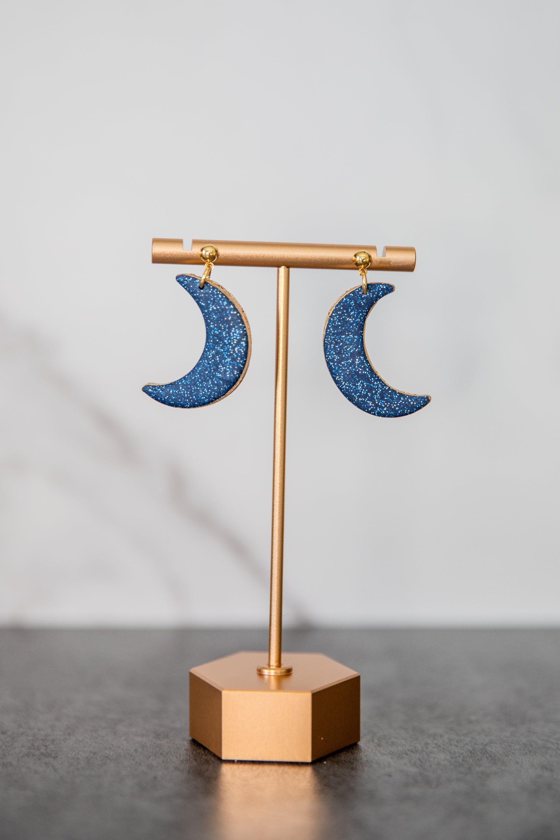 Blue glitter crescent moon earrings with gold edges