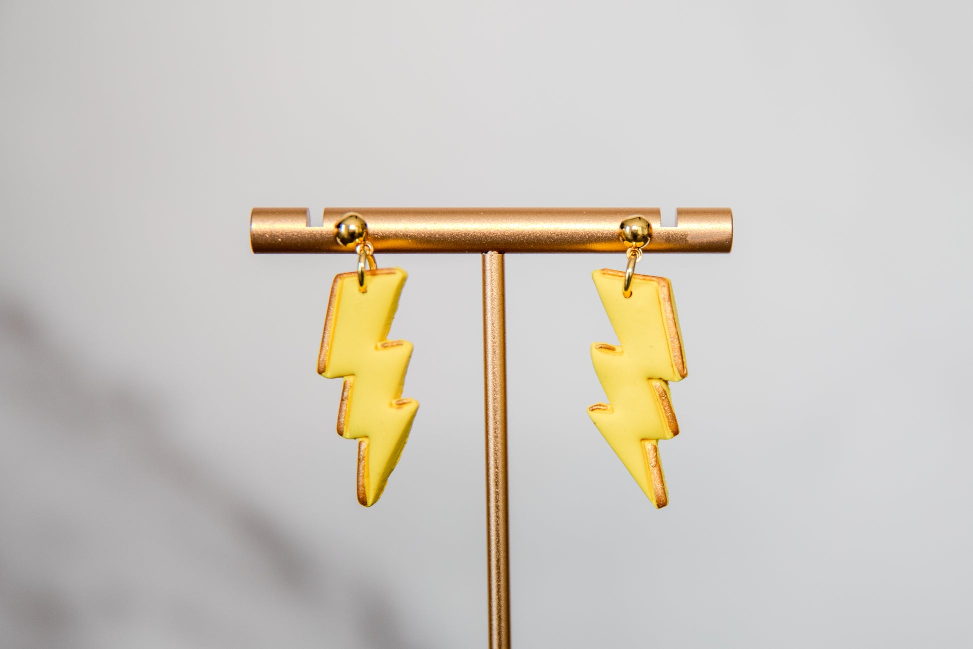 Yellow lightning bolt drop earrings with gold details