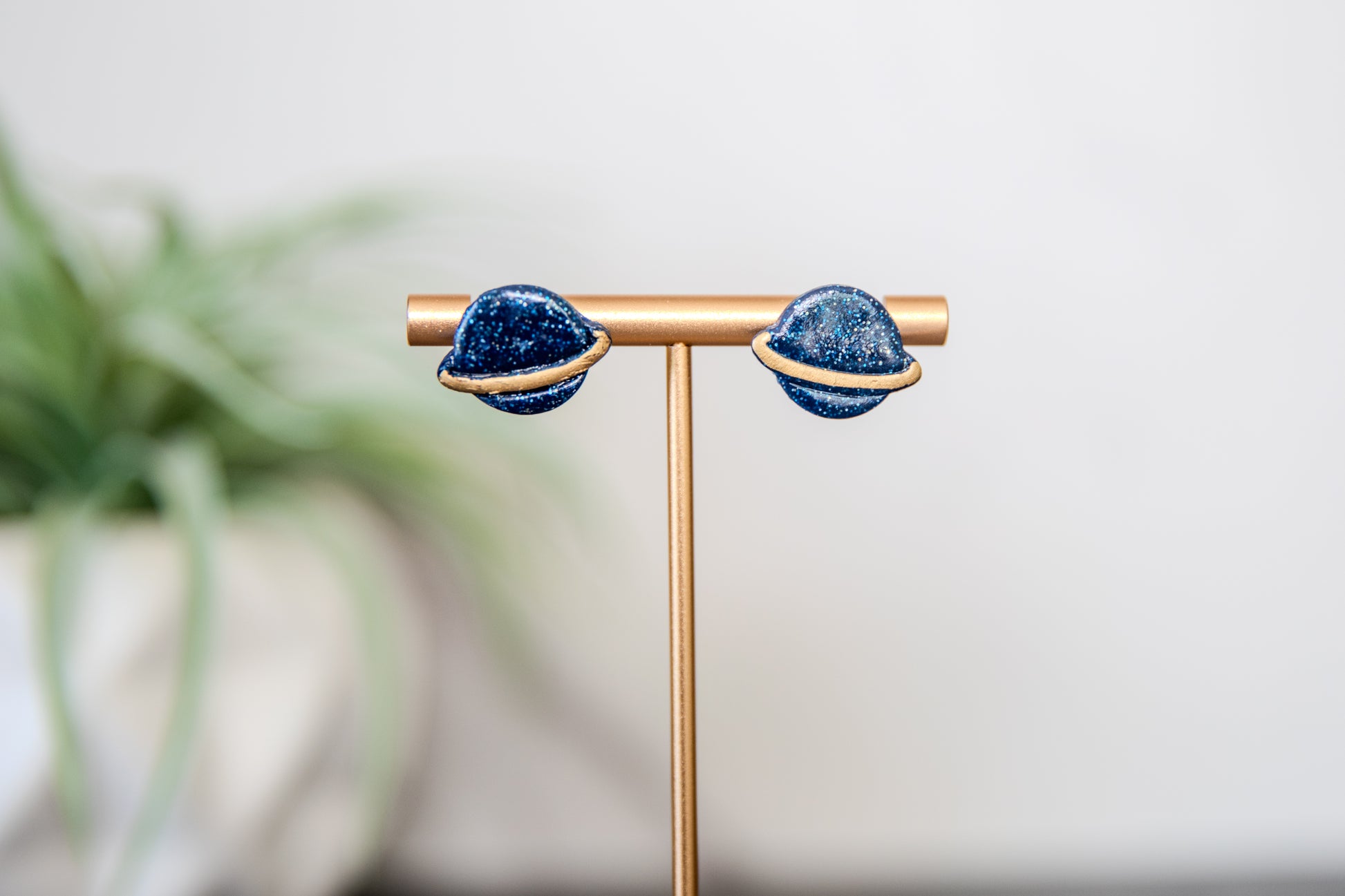 Blue glittery planet Saturn stud earrings with gold details