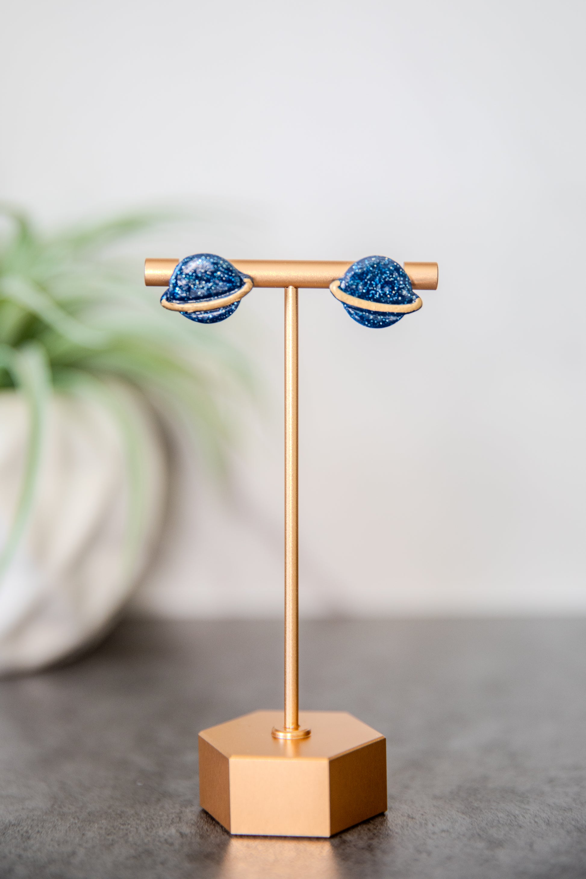 Blue glittery planet Saturn stud earrings with gold details