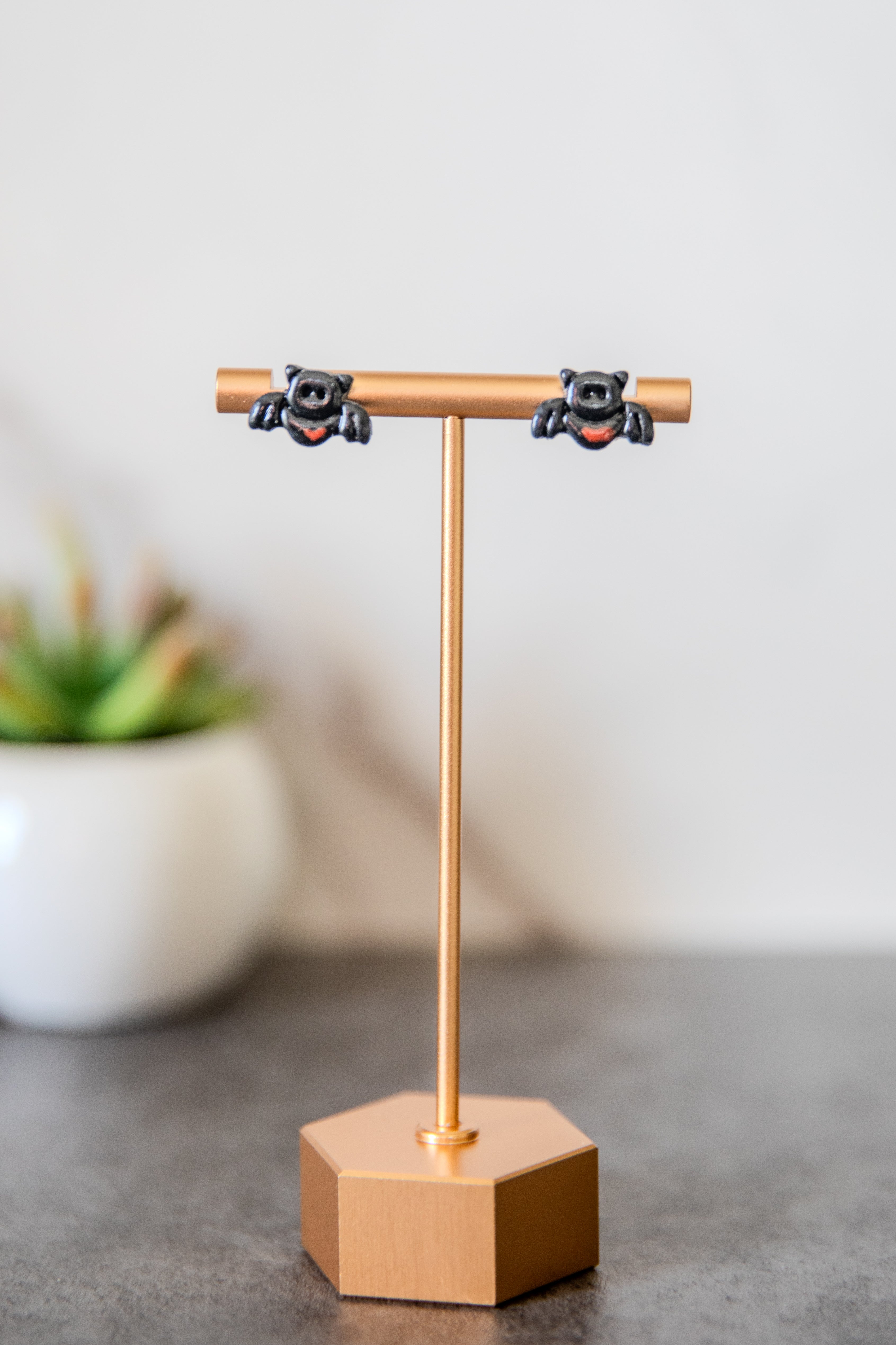 Bat stud earrings with small red hearts