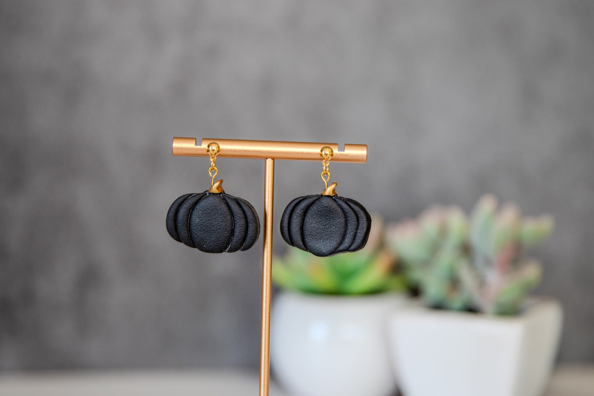 Black pumpkin drop earrings with gold accents