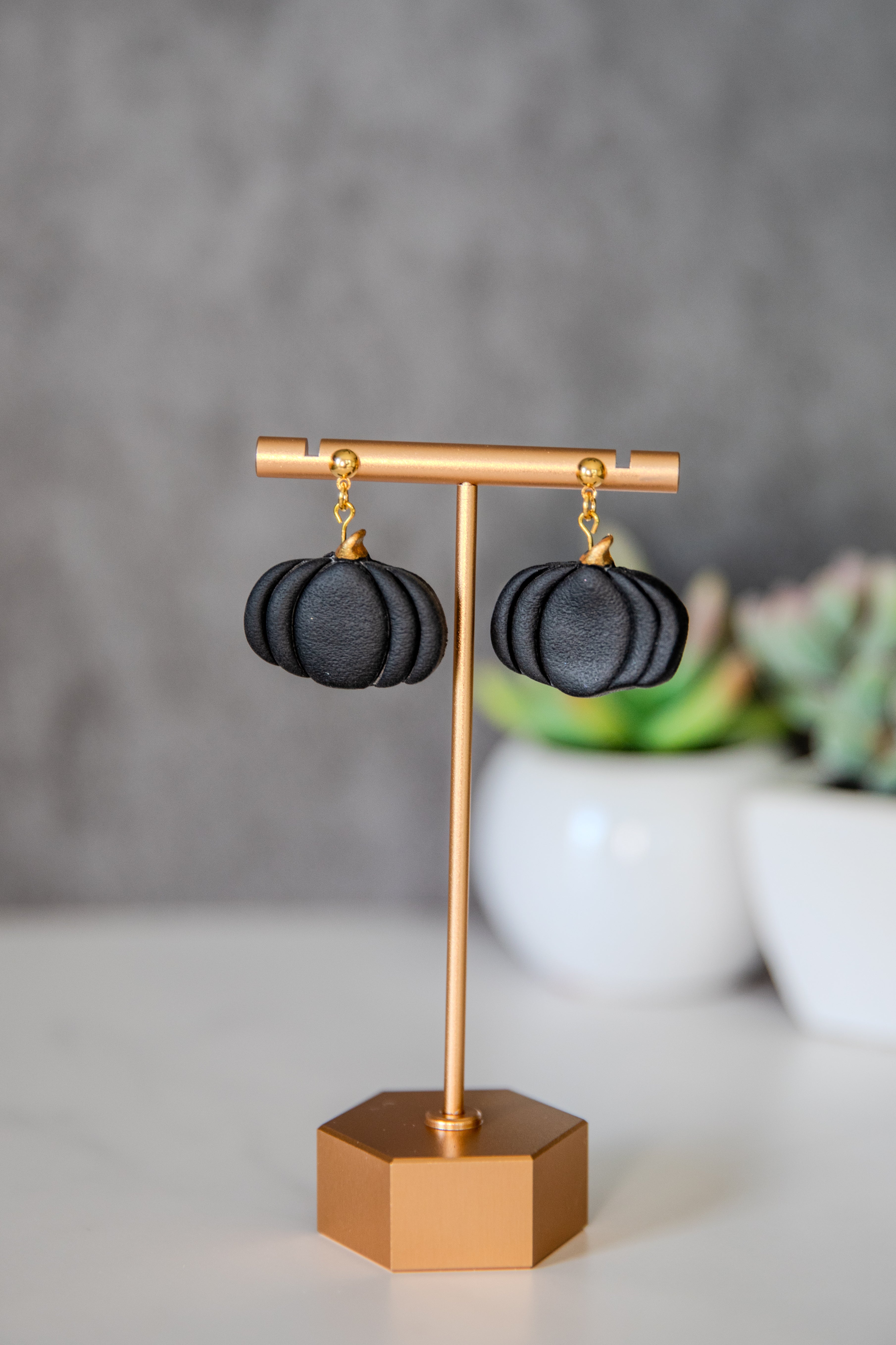 Black pumpkin drop earrings with gold accents