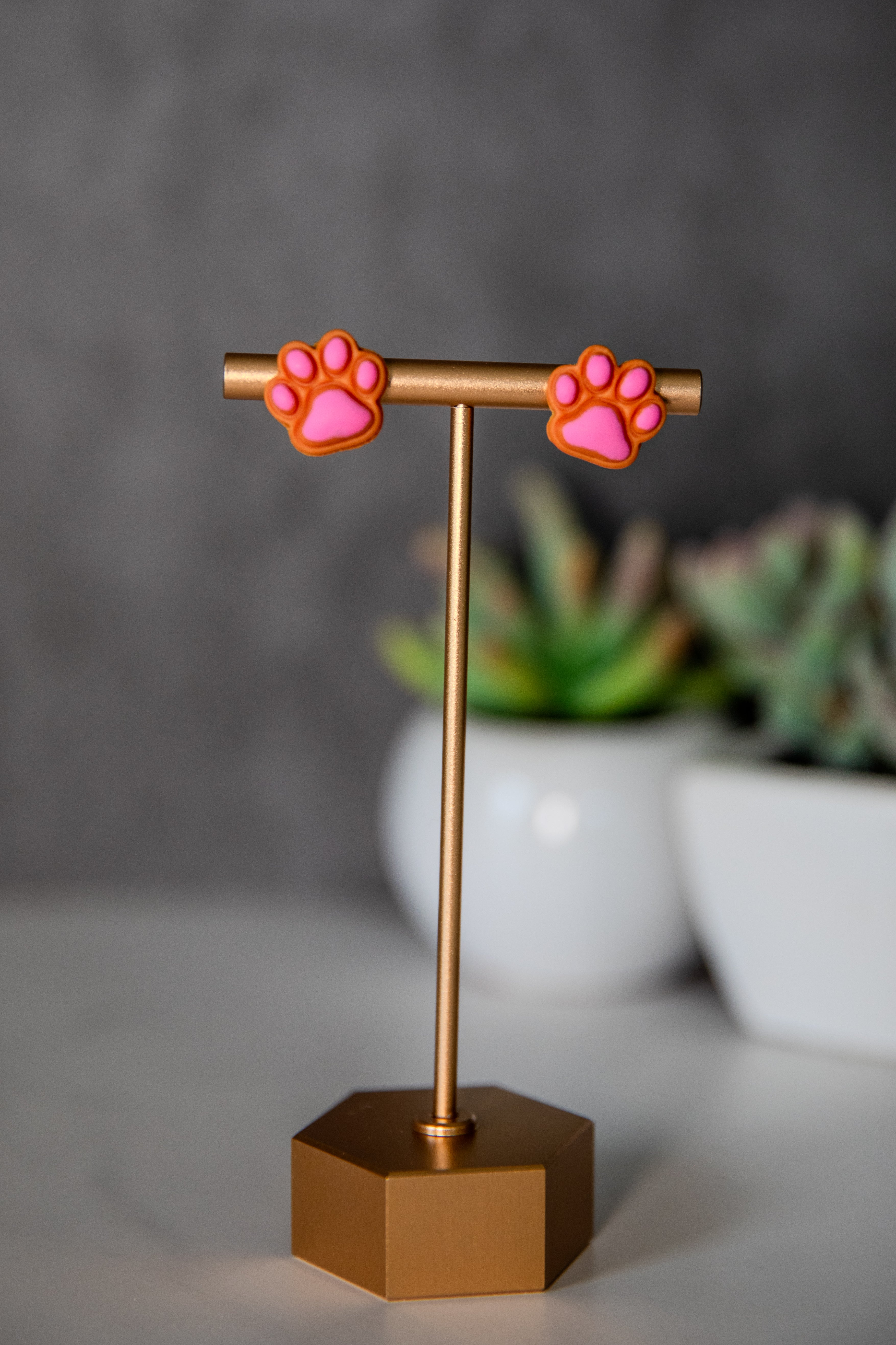 Orange paw print stud earrings with pink pads