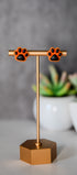 Orange paw print stud earrings with black pads