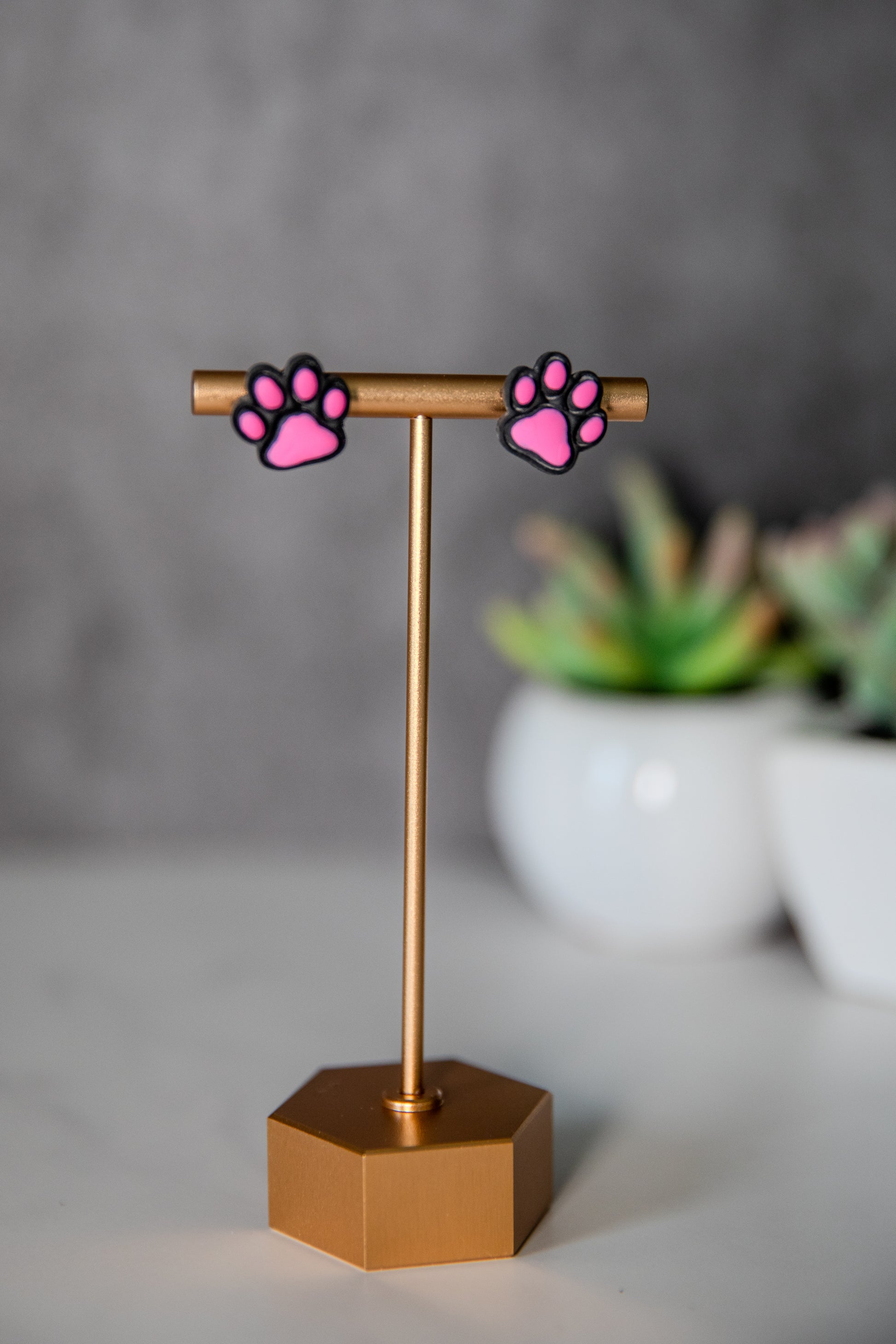 Black paw print stud earrings with pink pads