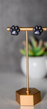 Black paw print stud earrings with shimmer pads