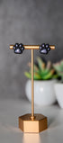 Black paw print stud earrings with shimmer pads