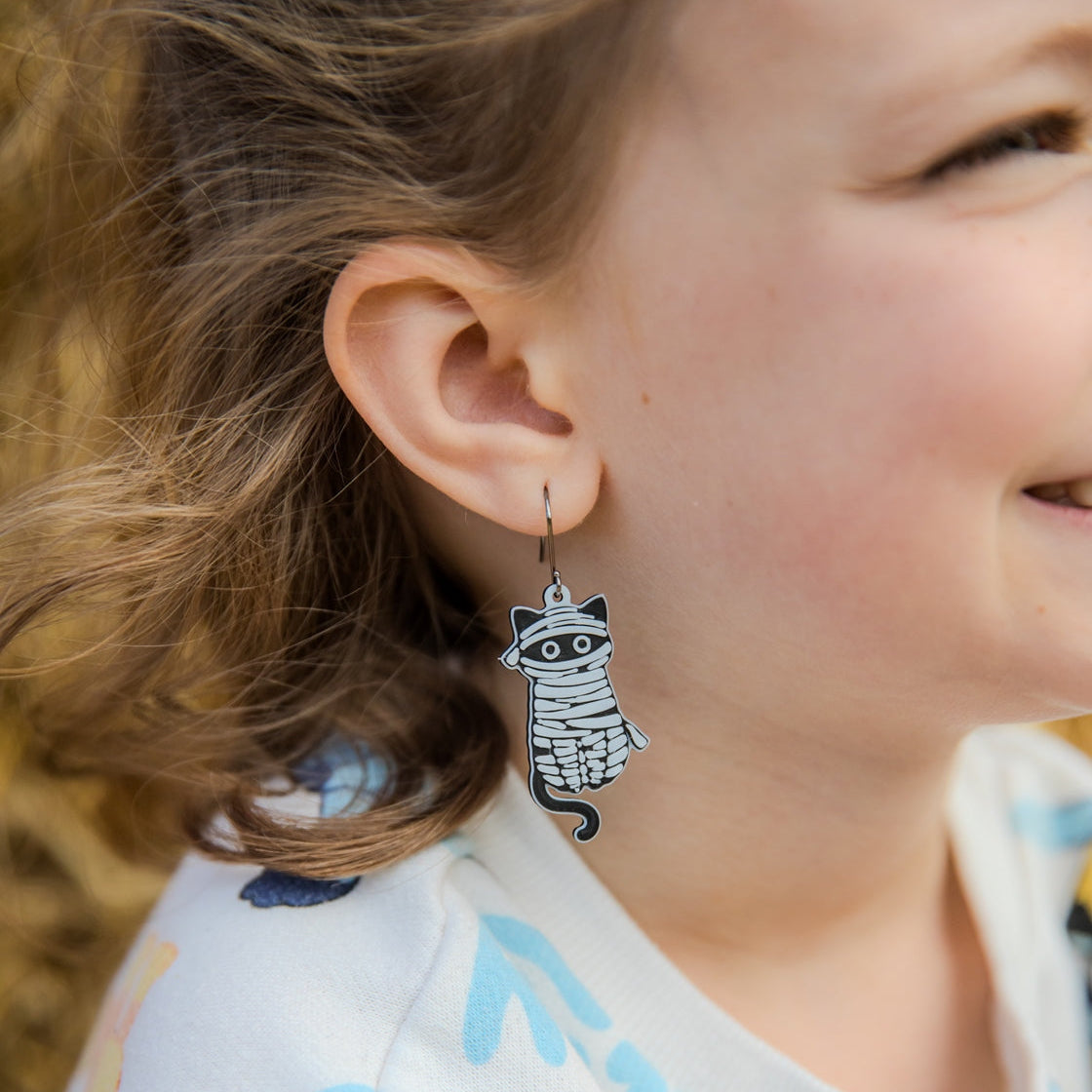 Girl wearing mummy cat earrings