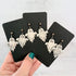 Glossy dangling ghost earrings with marble vein effect