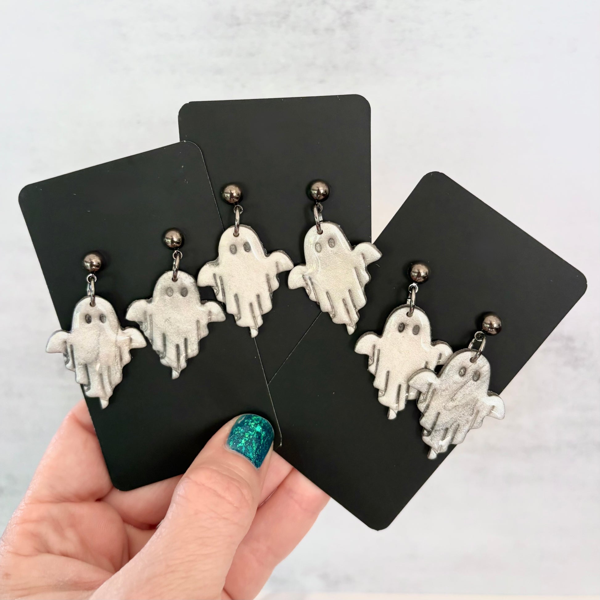 Glossy dangling ghost earrings with marble vein effect