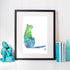 Framed artwork of a colorful cat silhouette on a white wall with decorative items.