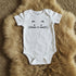 White baby onesie with a cat face design