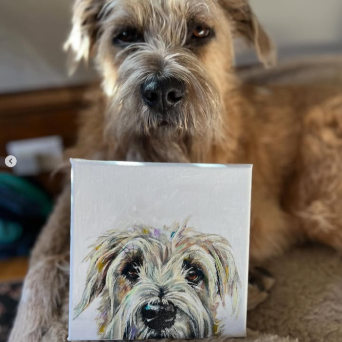 Dog looking at a painting of itself