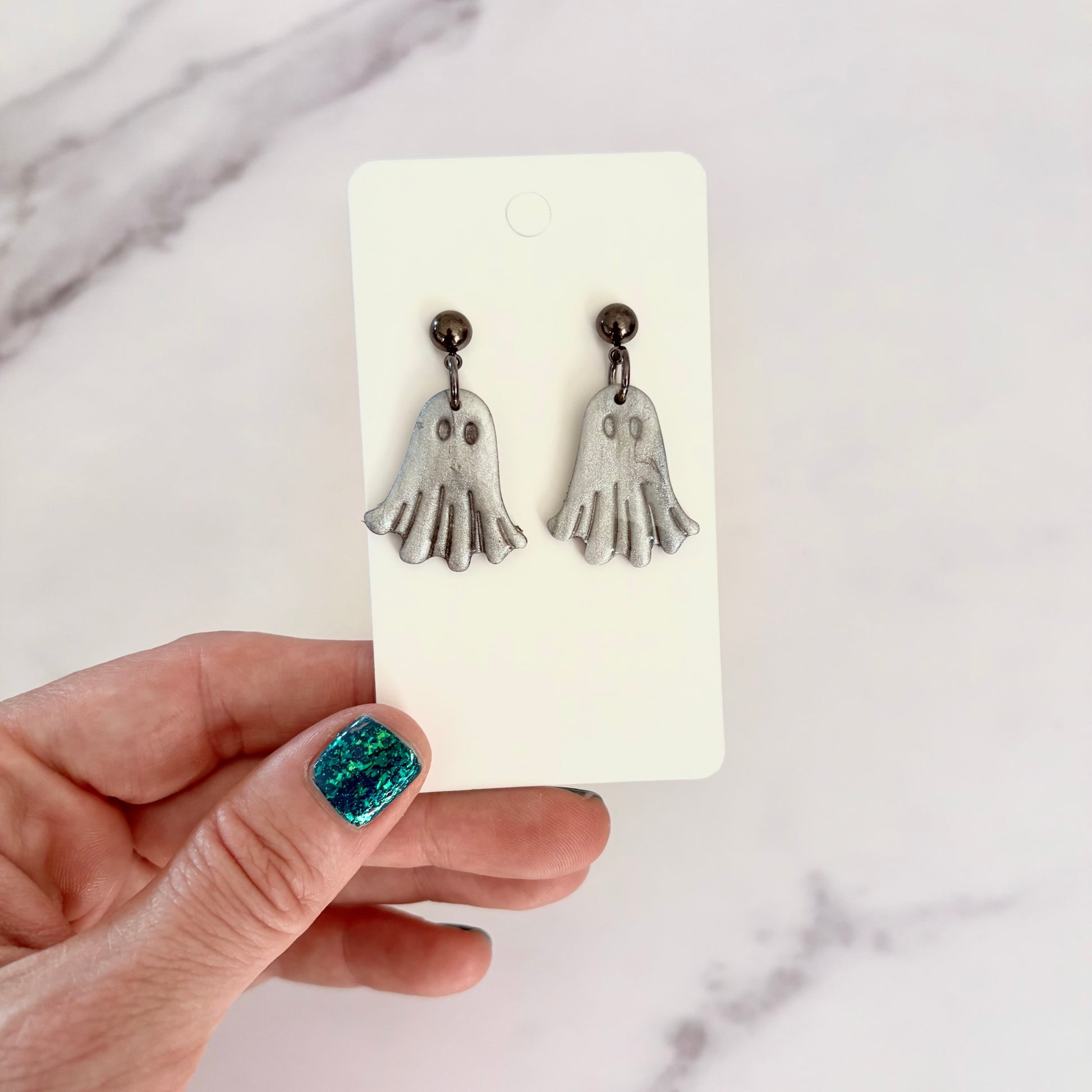 Glossy dangling ghost earrings with marble vein effect