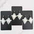 Glossy dangling ghost earrings with marble vein effect