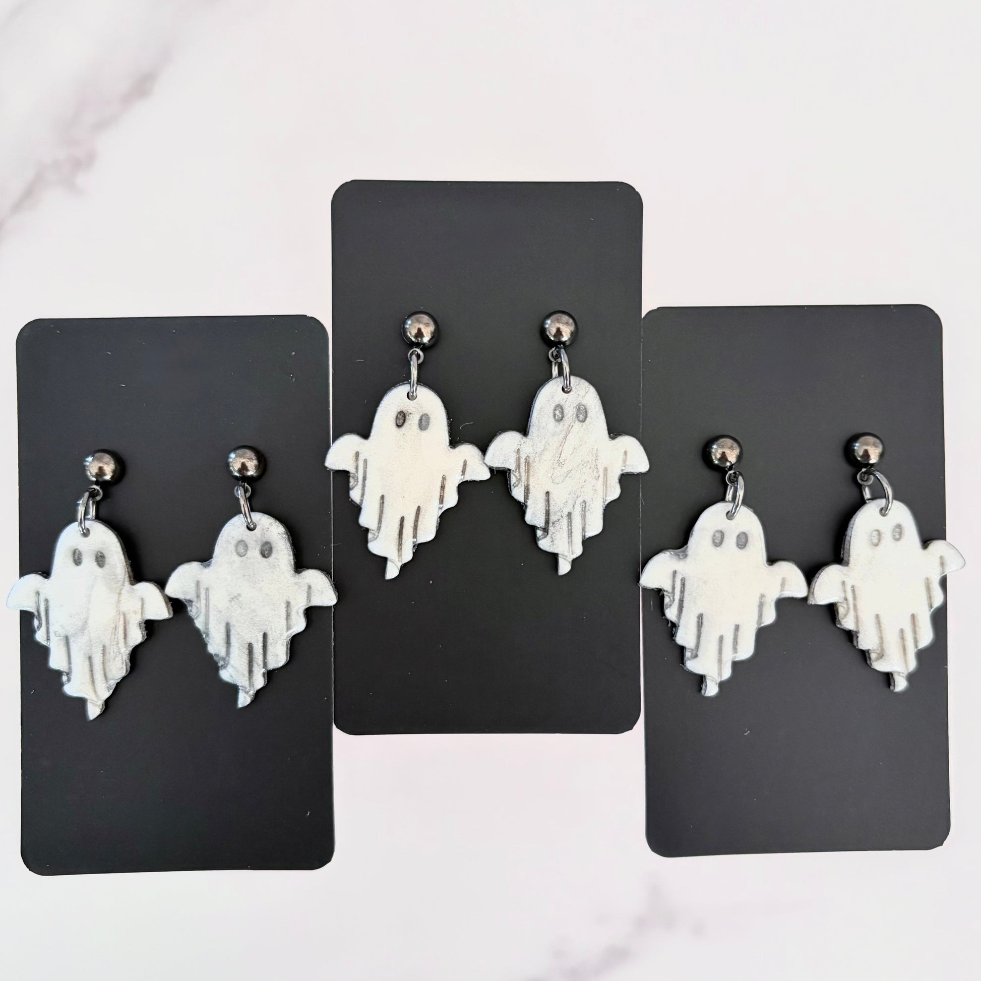Glossy dangling ghost earrings with marble vein effect