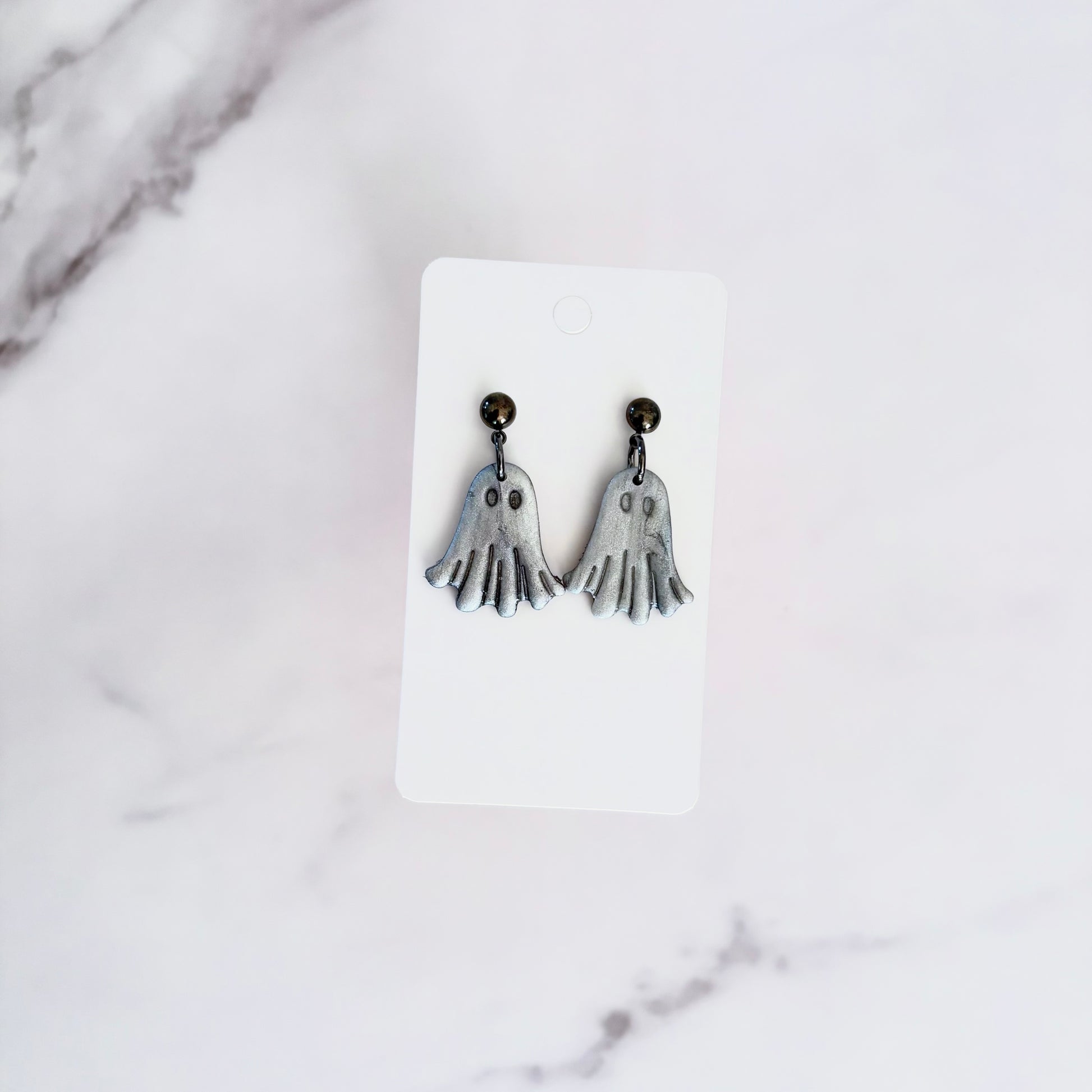 Glossy dangling ghost earrings with marble vein effect