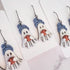 Hanging earrings featuring ghosts holding pumpkins and wearing beanie hats