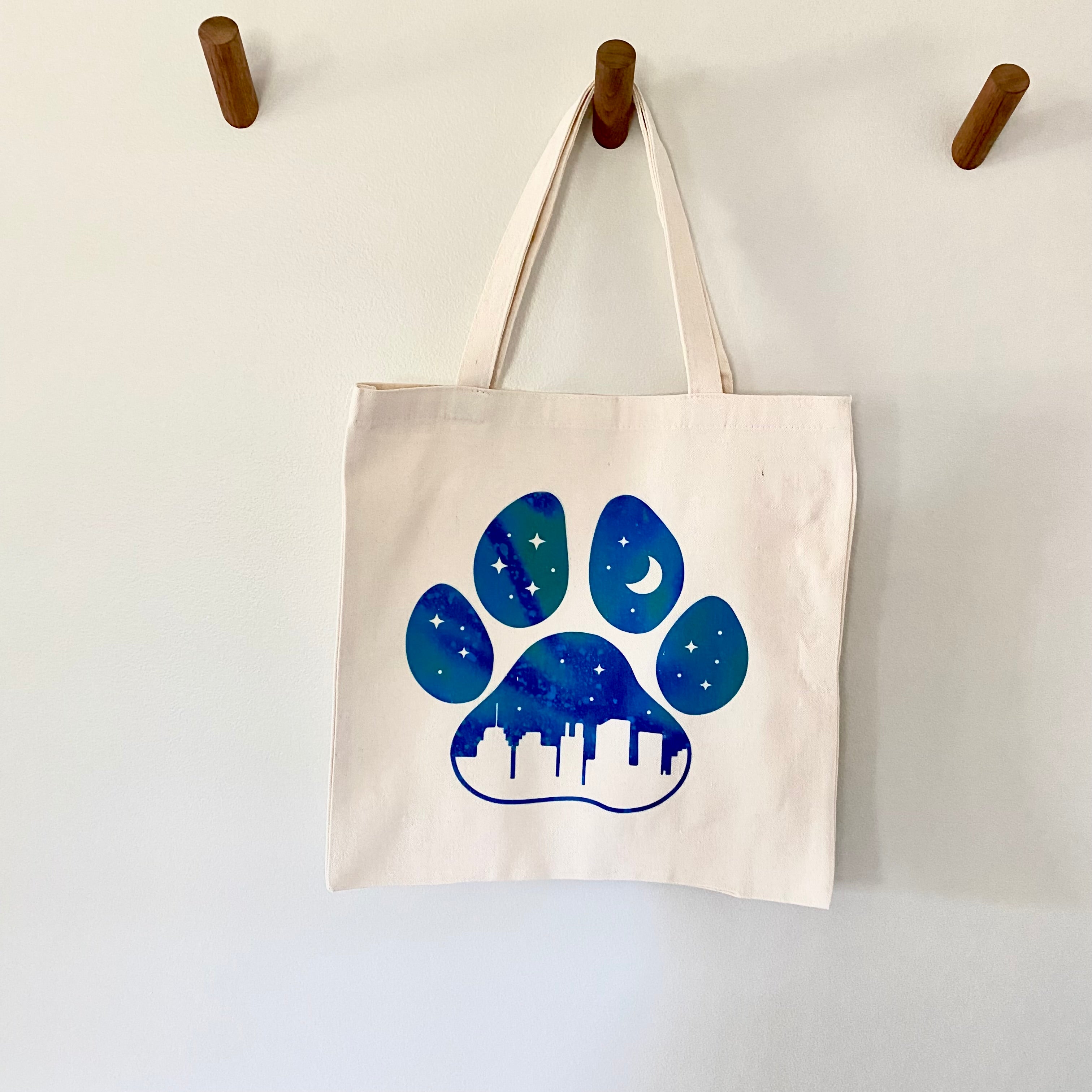 Tote bag with a blue paw print in the city design 