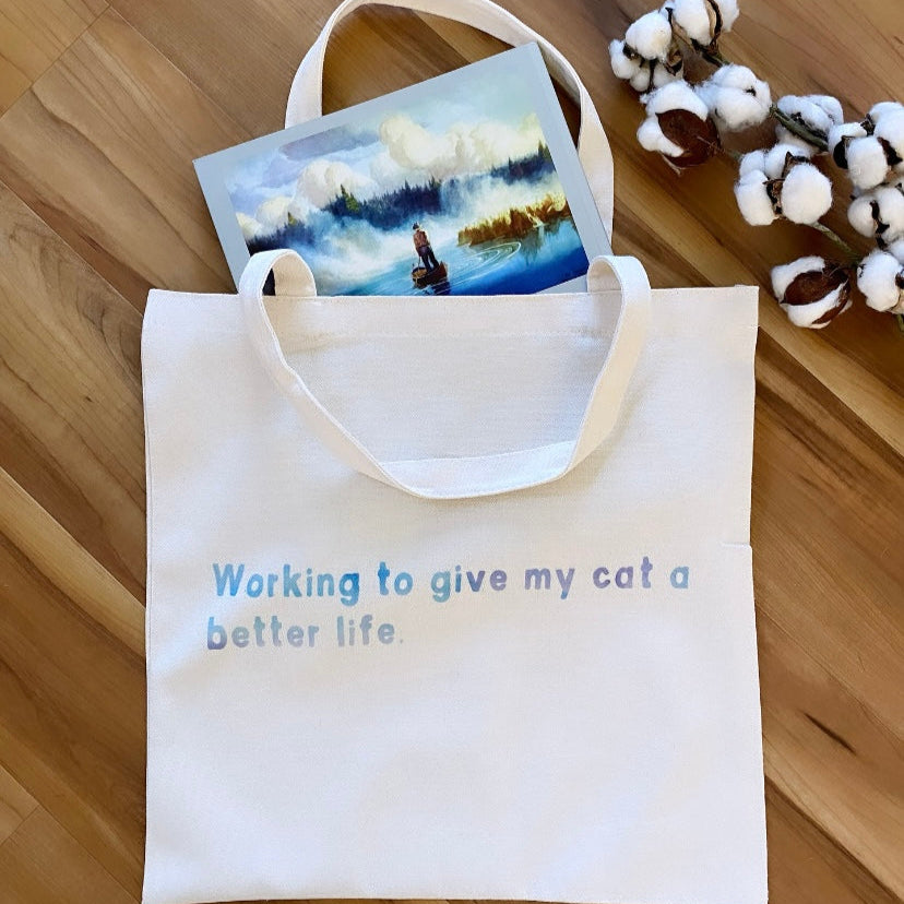 Tote bag with printed text and a card on a wooden surface