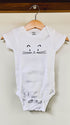 White baby onesie with a cat face design