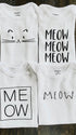 Four white baby onesies with cat-themed designs
