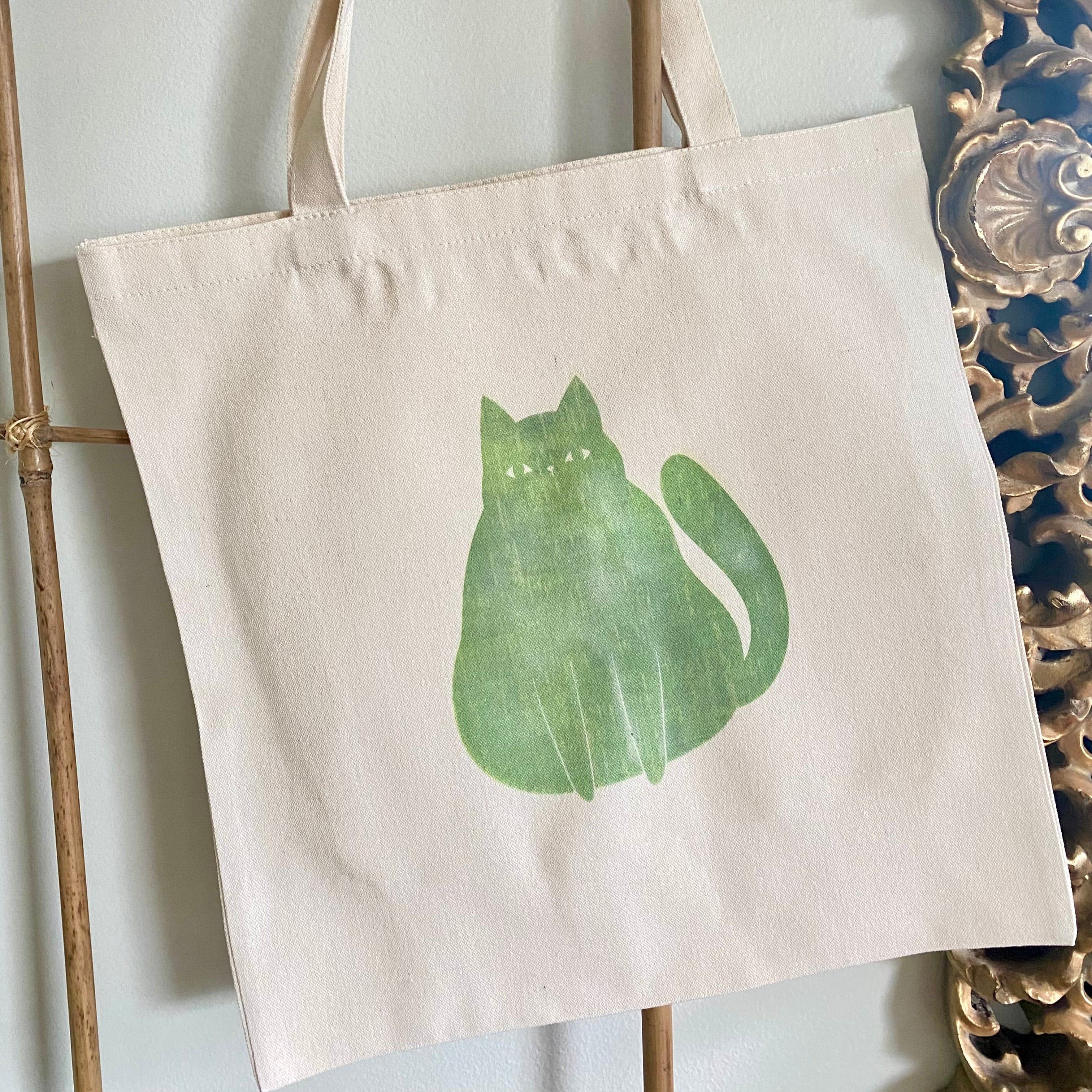 Tote bag with a green cat design on a white background