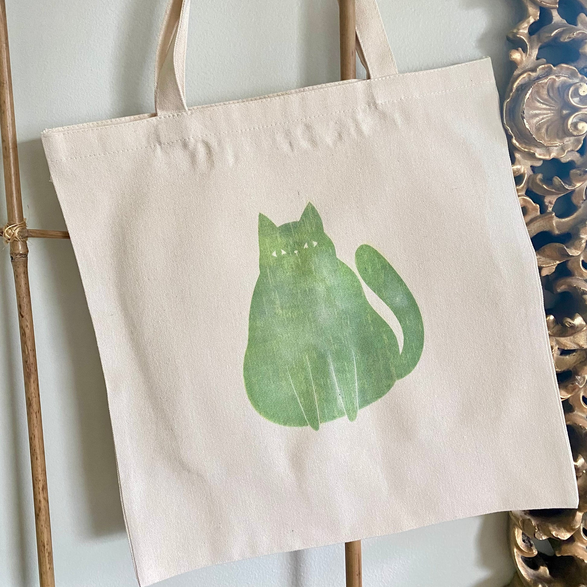 Tote bag with a green cat design on a white background