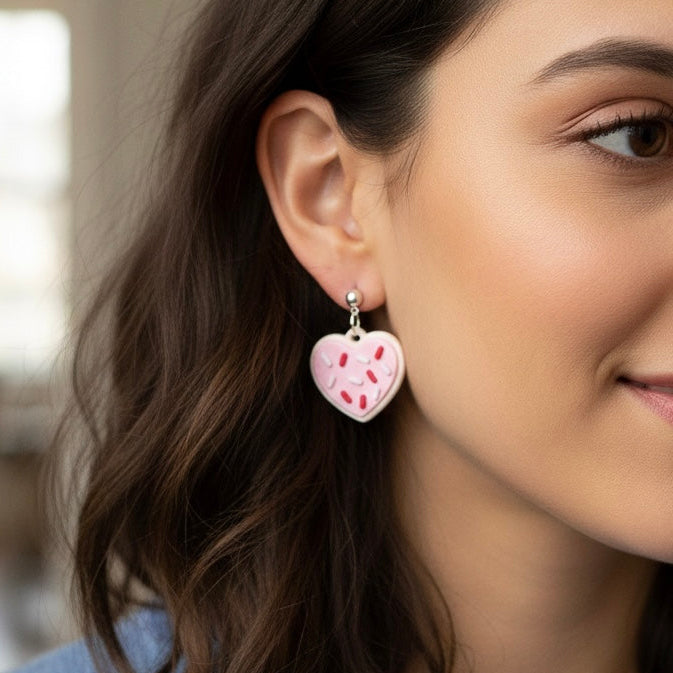 Woman wearing a heart-shaped earring with a blurred indoor background