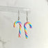 Rainbow striped candy cane earrings on a white background