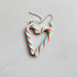 Heart-shaped candy cane earrings on a light gray background