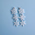 Snowflake-shaped earrings on a light blue background
