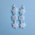 Snowflake earrings on a light blue background