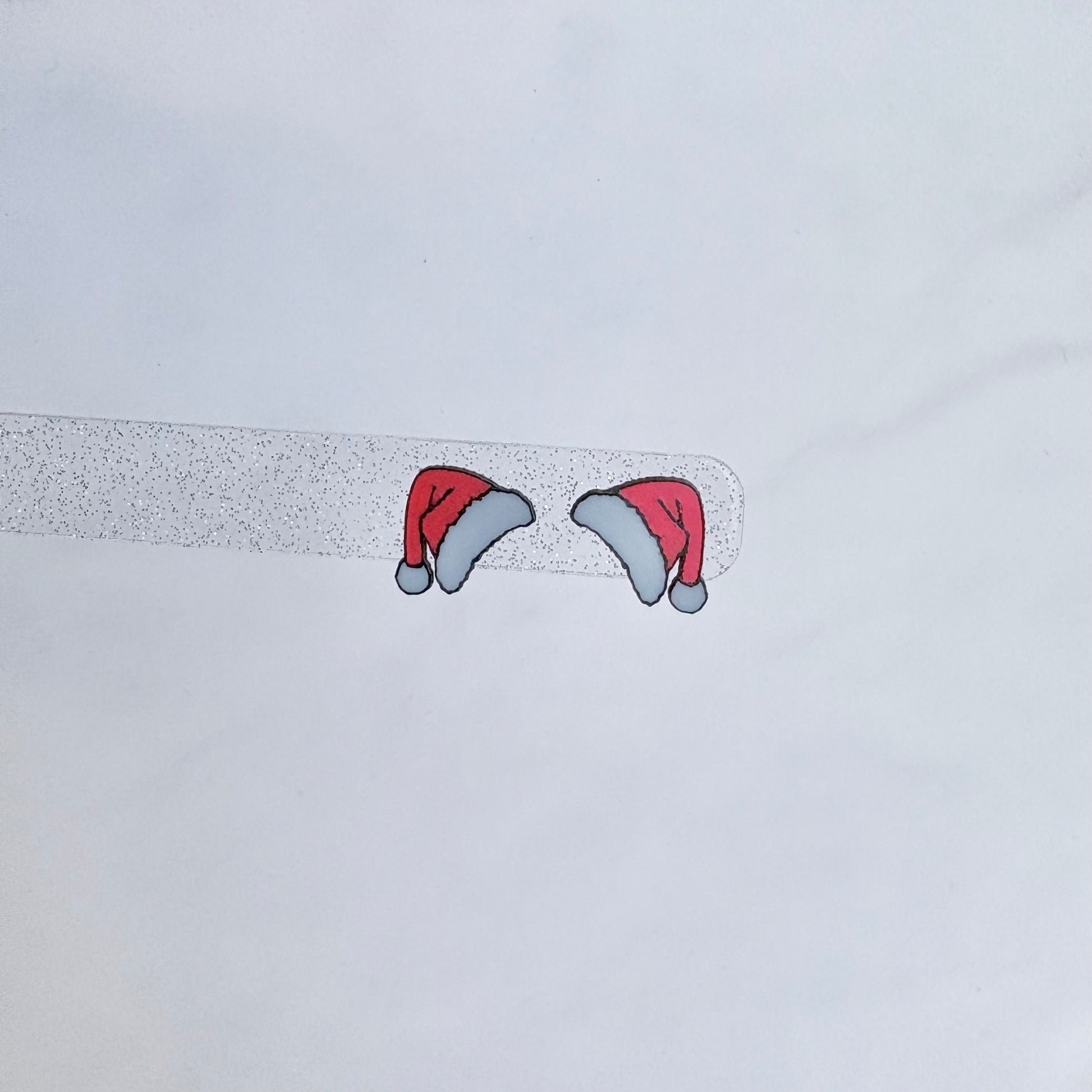 Two cartoonish red hats with gray bases on a light gray background