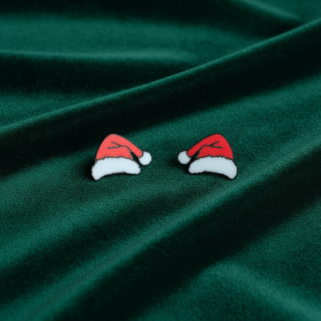 Pair of Santa hat earrings on a marble surface
