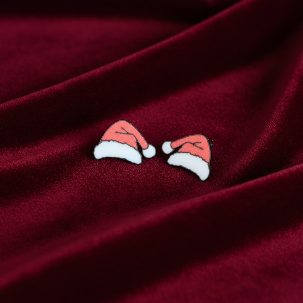 Pair of Santa hat earrings on a light gray background