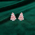 Pair of Christmas tree-shaped earrings on a light gray background