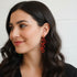 Woman wearing red earrings with a neutral background