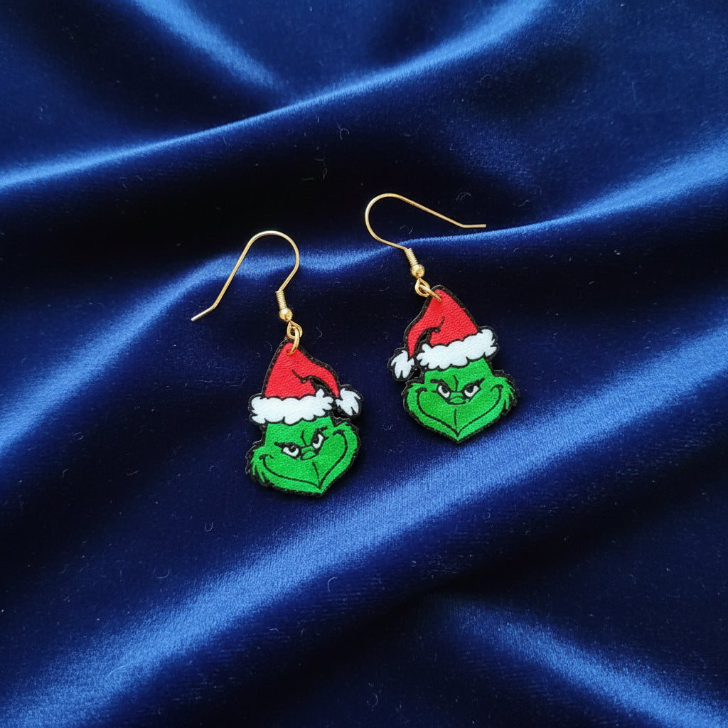 Green Grinch face earrings with Santa hats on a white background