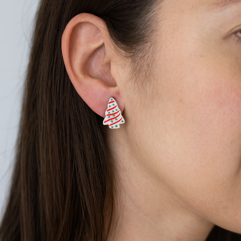 Close-up of a person wearing a Christmas tree-shaped earring.