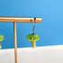 Green mushroom-shaped earrings on a gold stand against a blue background