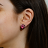 Close-up of a person wearing pink paw print earrings.