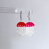 Jellyfish-shaped earrings with red tops and pink undersides on a white background