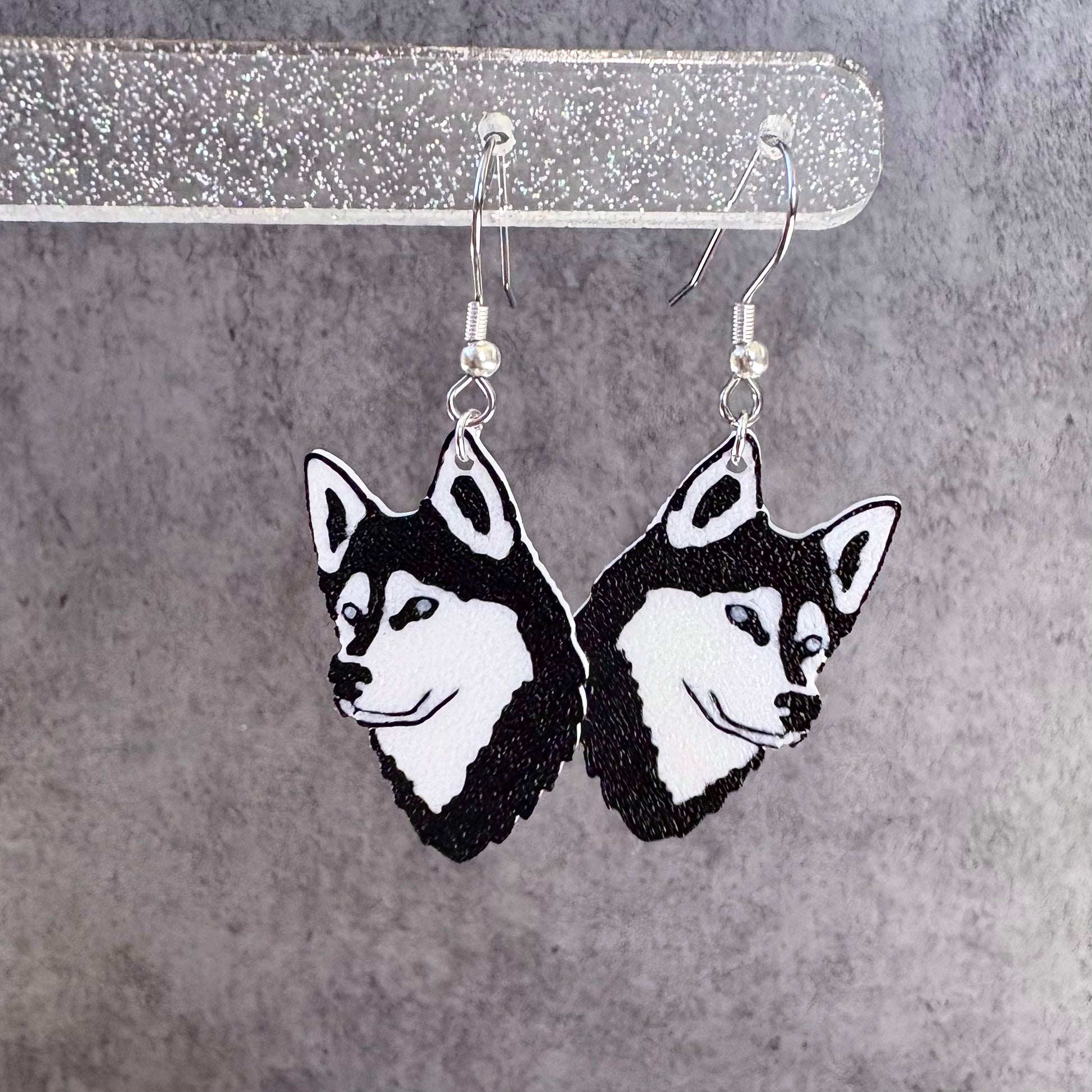 Husky dog face earrings on a gray background